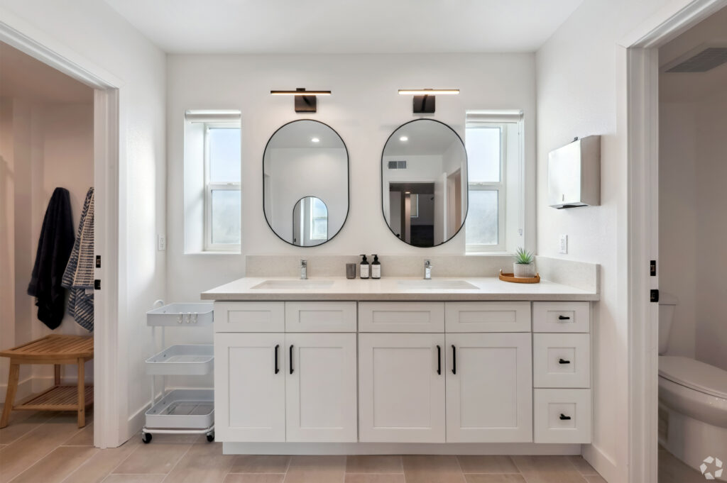 Modern shared bathroom with dual sinks and stylish mirrors at Nest Housing near USC.